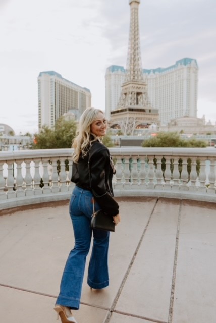 Jamie Boyack standing on a bridge in Las Vegas in a black jacket and blue jeans