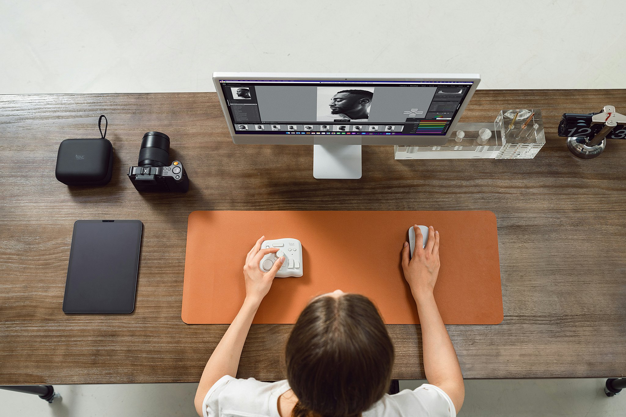 A look down over the shoulder of an artist editing photos in Lightroom