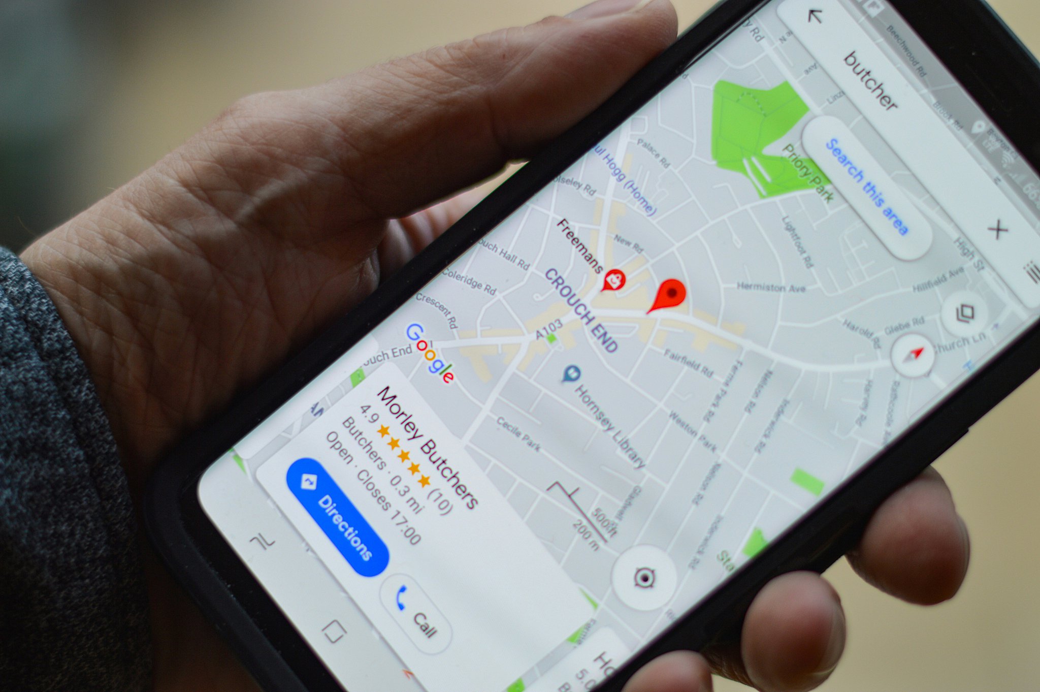 A business listing appears on a cell phone in someone's hand on their map app after they used how to list your business on google