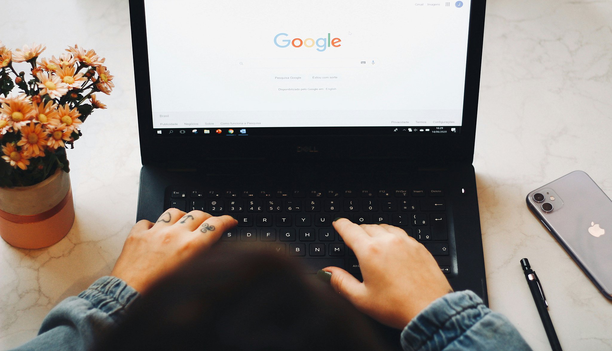 A look down over someone typing into google on a laptop for how to list your business on google