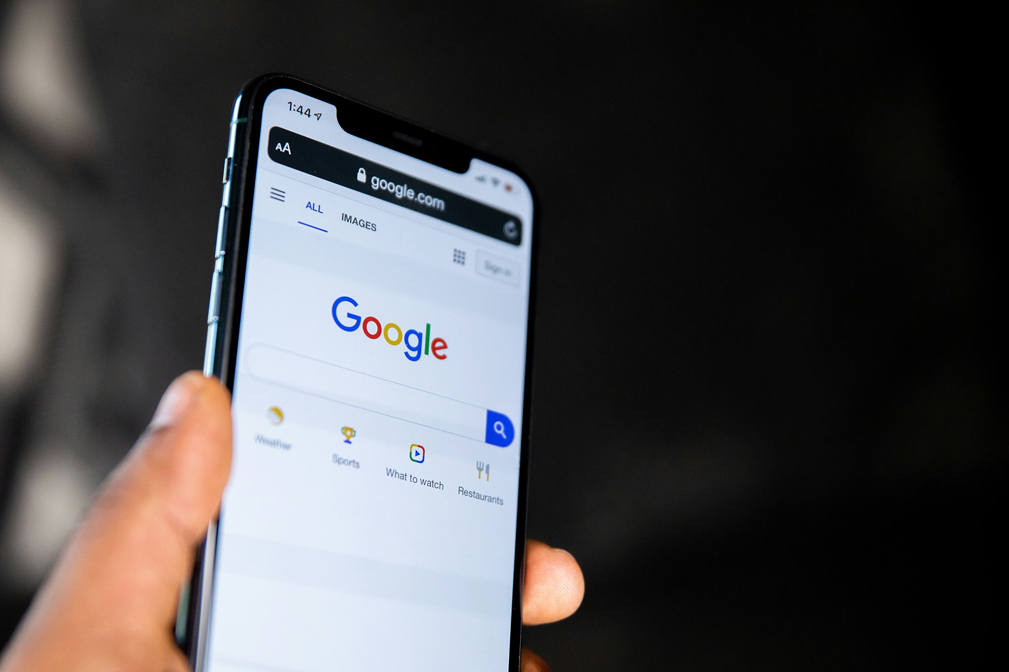 Details of a google search engine page brought up on a cellphone in someone's hand after exploring how to list your business on google