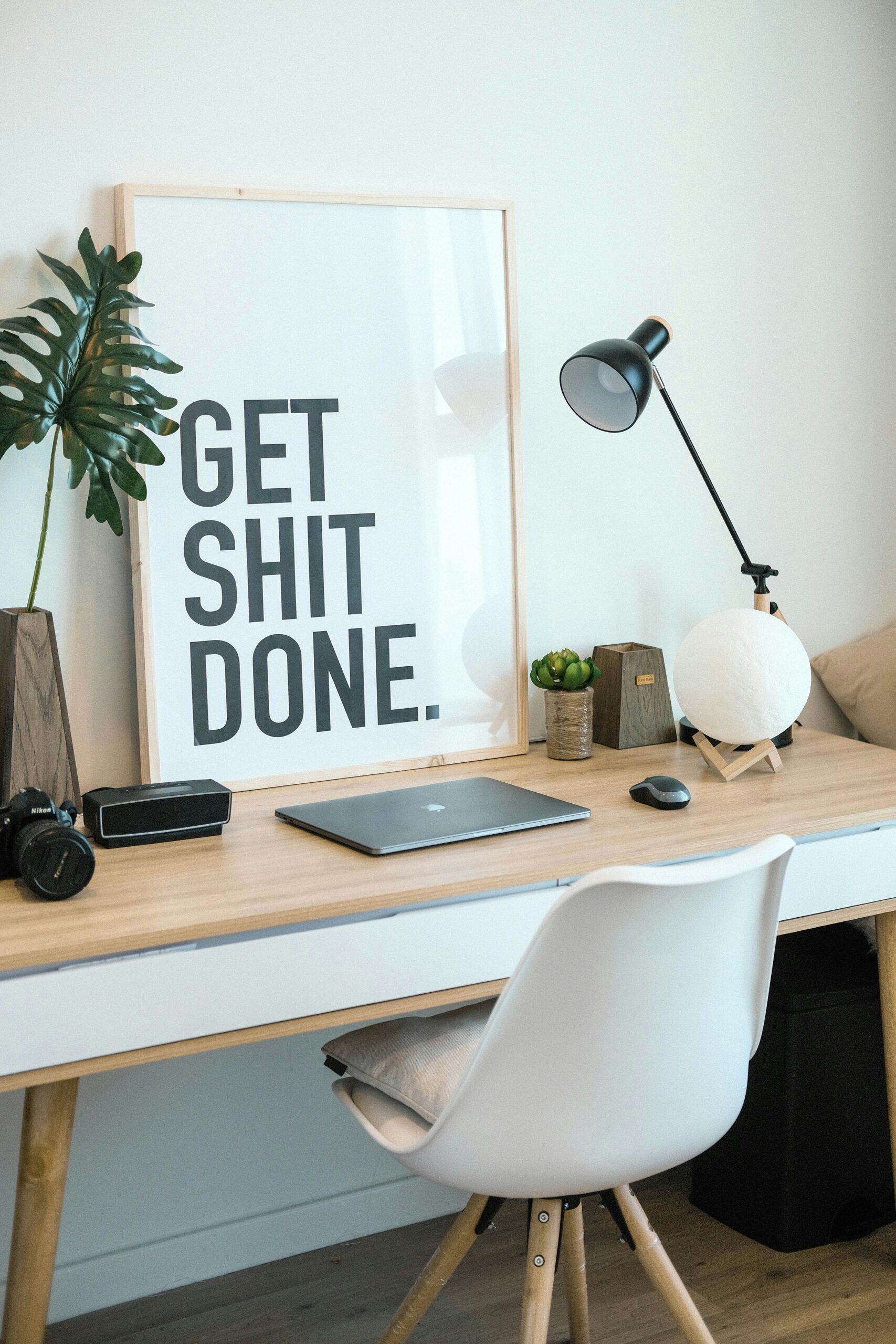 Details of a desk with a laptop and camera on it of a photographer who wants to outsource blog writing